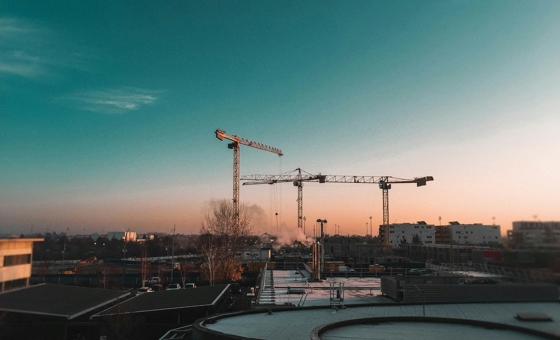 Immagine di una gru in un cantiere al tramonto